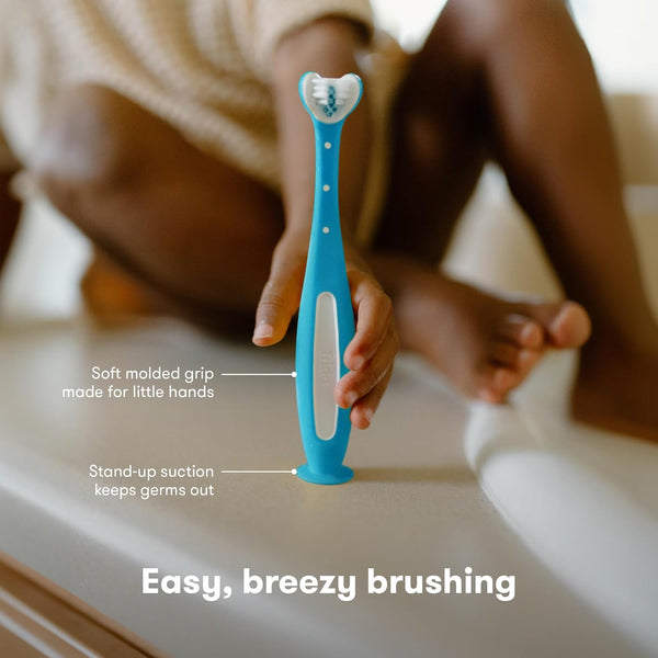 Frida Baby Training Toothbrush | Toddler Toothbrush for 18-24 Months, Easy-Grip Handle, Triple Angle Bristles, Soft Toothbrush Bristles, Stay-Put Suction Cup | Blue