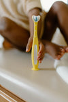 Frida Baby Training Toothbrush | Toddler Toothbrush for 18-24 Months, Easy-Grip Handle, Triple Angle Bristles, Soft Toothbrush Bristles, Stay-Put Suction Cup | Yellow